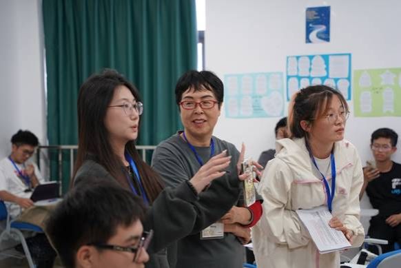 A group of people standing in a roomDescription automatically generated